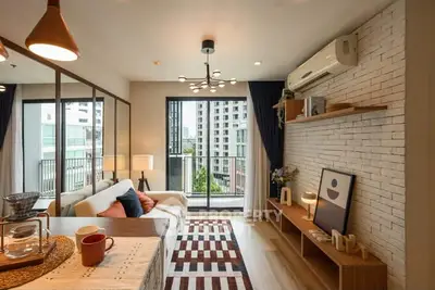 Modern living room with stylish decor and balcony view in urban apartment.