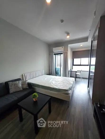 Modern studio apartment with cozy living area and large window view