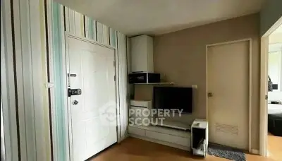 Modern living room with stylish striped wallpaper and sleek entertainment unit.