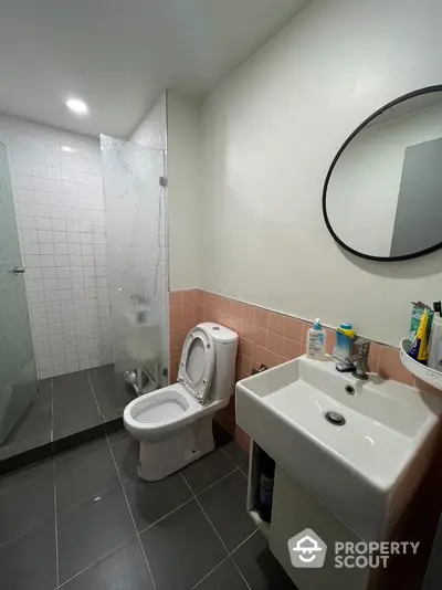 Modern bathroom with glass shower and sleek fixtures in contemporary home.