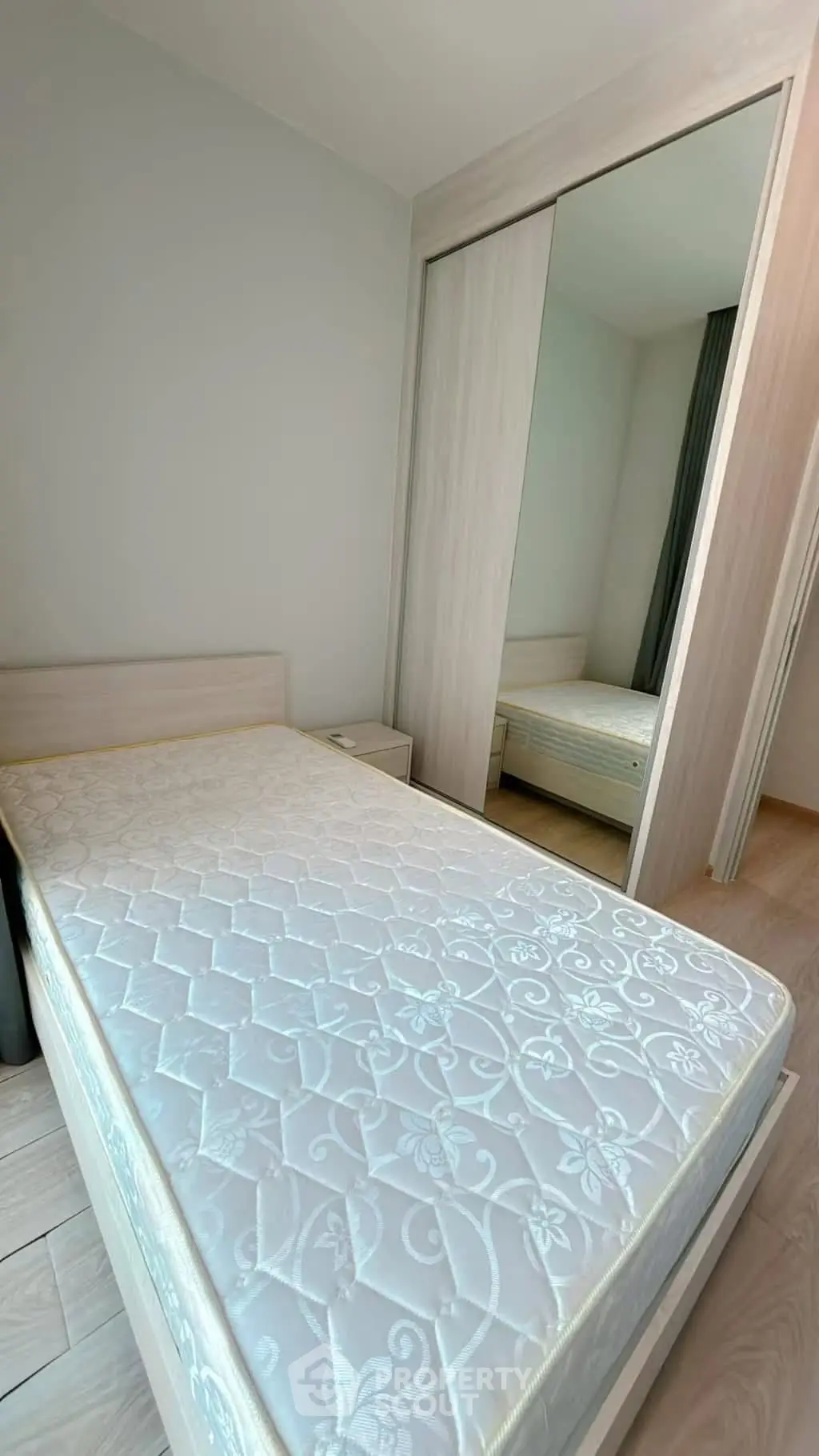 Spacious bedroom with modern design and large mirrored wardrobe