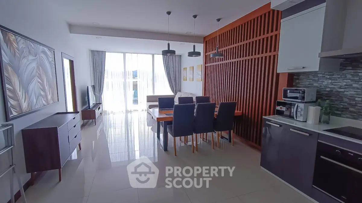 Modern open-layout living room and kitchen with stylish decor and ample natural light.