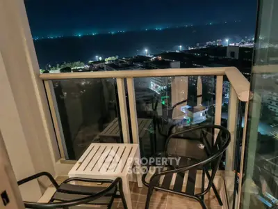 Stunning night view from a cozy balcony overlooking city lights and ocean horizon.