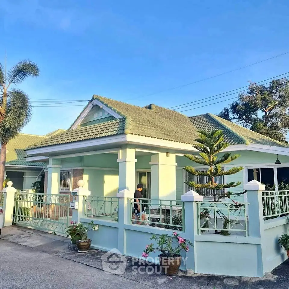Charming single-story home with green roof and fenced yard, perfect for family living.