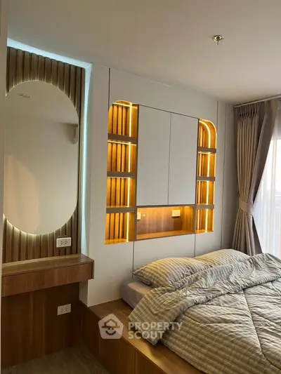 Modern bedroom with stylish lighting and cozy bedding in a contemporary apartment.