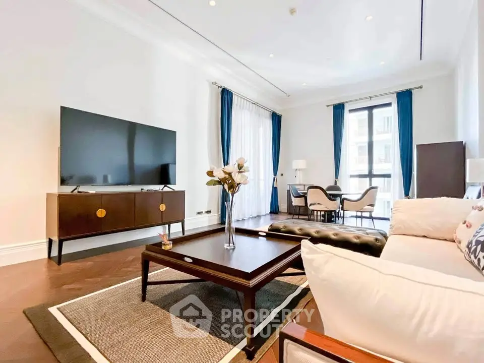 Elegant living room with modern decor and large TV, featuring a cozy seating area and dining space.