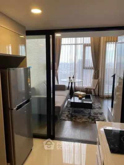 Modern apartment with open kitchen and cozy living room featuring large windows and stylish decor.