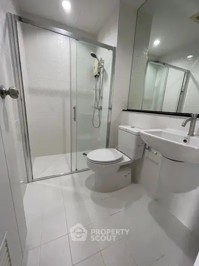 Modern bathroom with glass shower and sleek fixtures in a contemporary home.