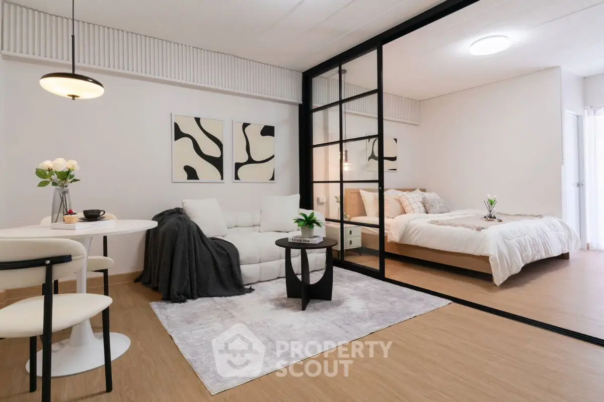 Modern open-plan living room and bedroom with stylish decor and glass partition