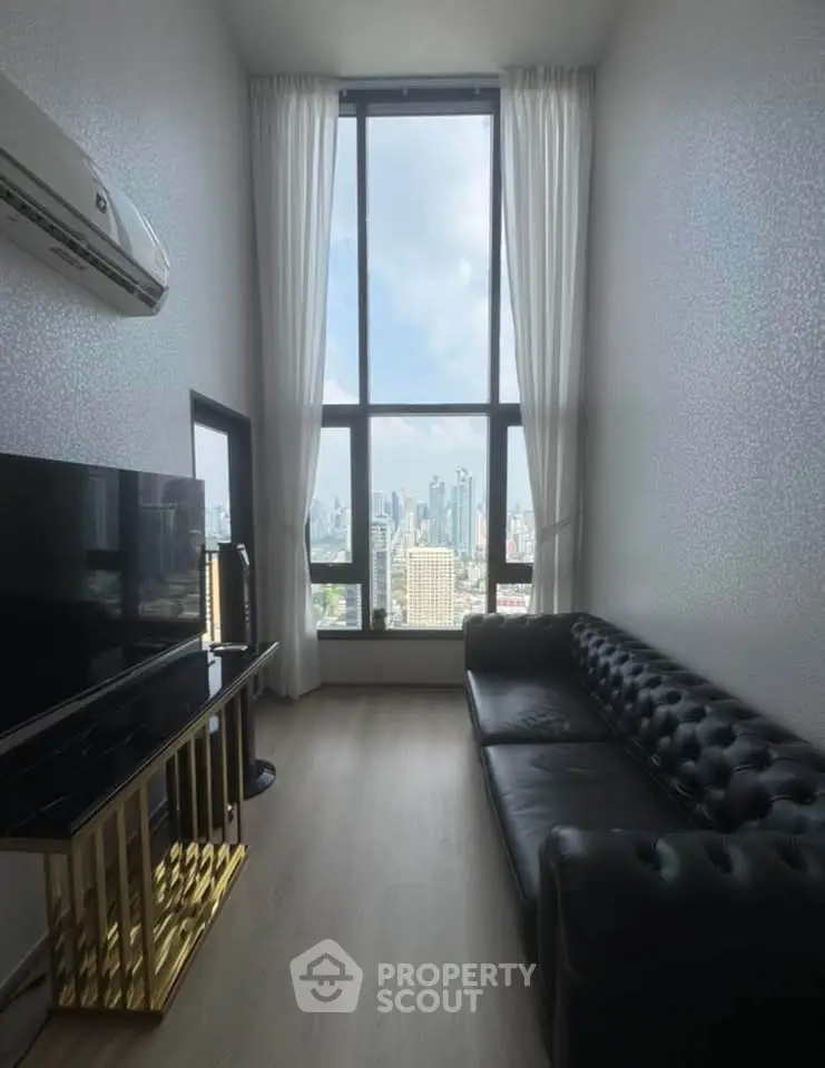 Luxurious high-rise living room with stunning city view and elegant black leather sofa.