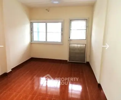 Spacious unfurnished room with tiled flooring and large window, perfect for customization.