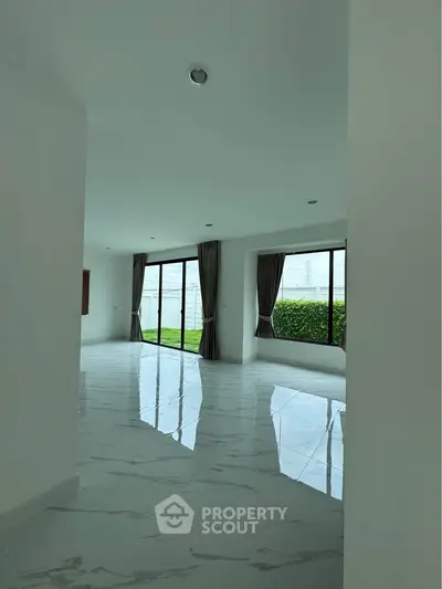 Spacious modern living room with large windows and marble flooring