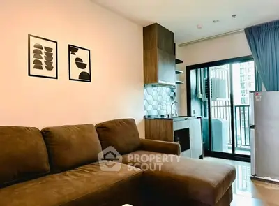 Modern living room with cozy brown sofa and stylish kitchen in open layout apartment.