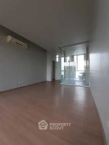 Spacious modern living room with wooden flooring and glass partition