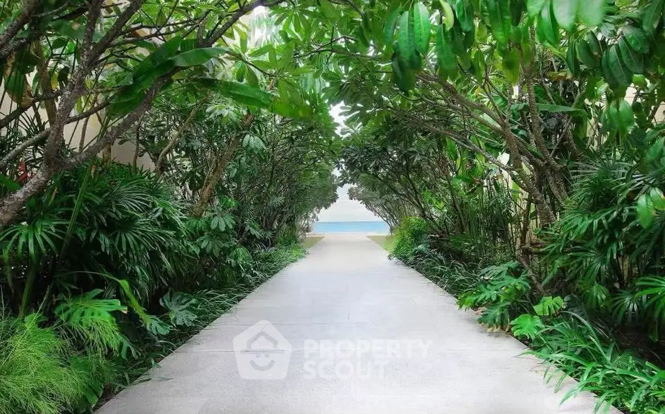 Lush garden pathway leading to a serene ocean view, perfect for tranquil living.