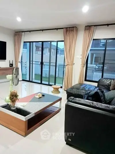 Spacious living room with modern decor and large windows for natural light.