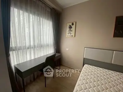 Modern bedroom with sleek desk and large window, perfect for a cozy living space.