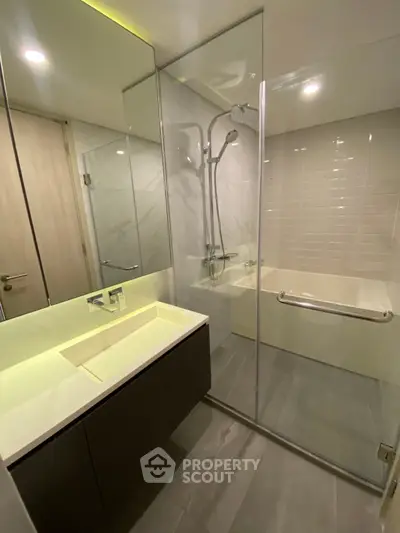 Modern bathroom with glass shower and sleek vanity in luxury apartment