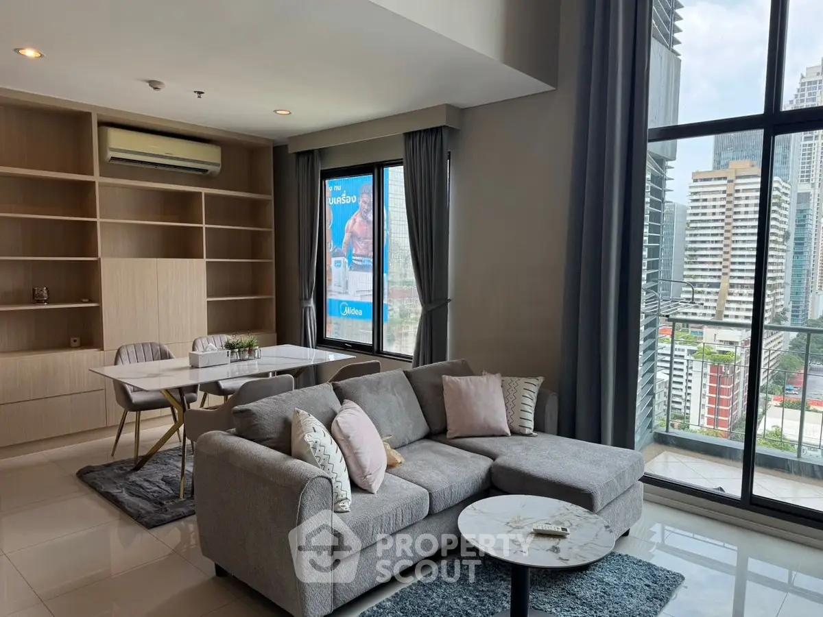 Modern living room with city view, featuring a cozy sofa, elegant dining area, and large windows.