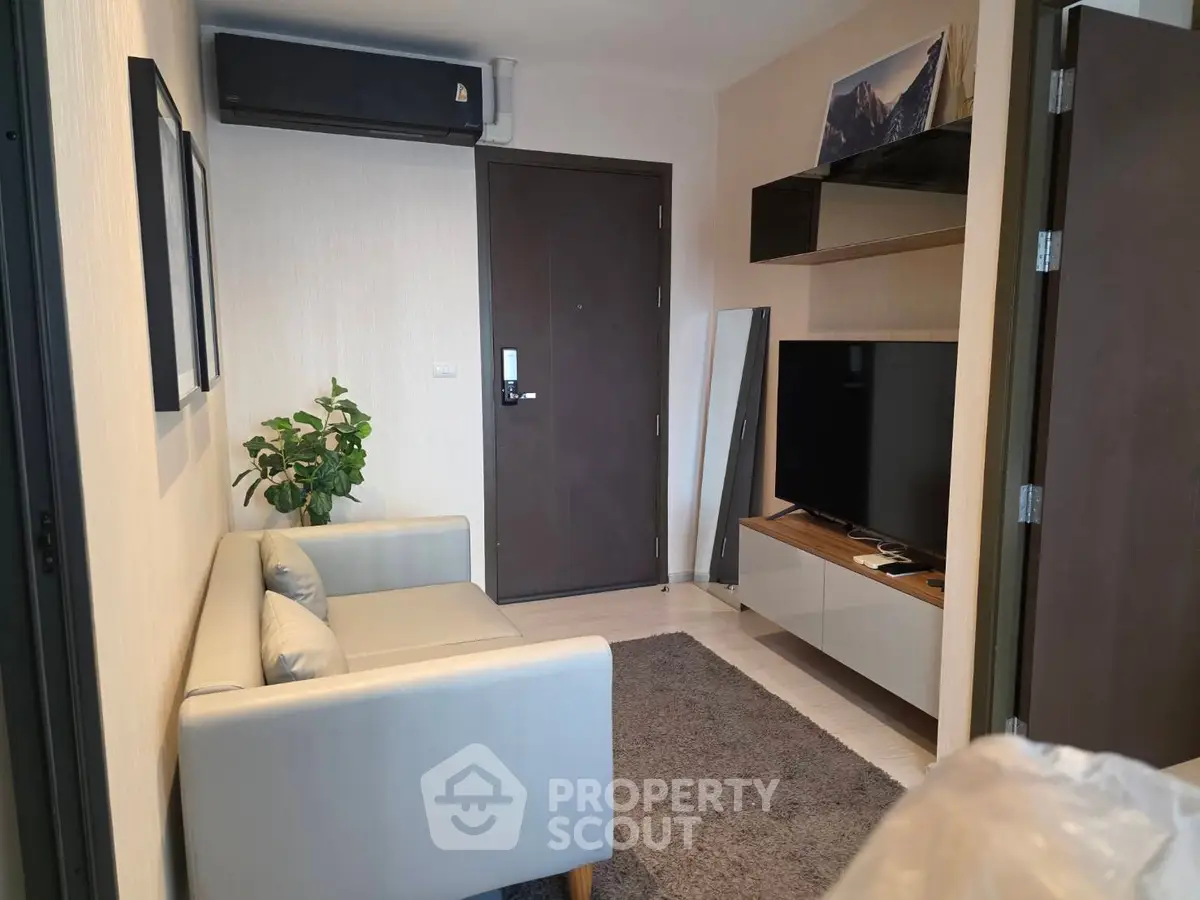 Cozy living room with modern decor and wall-mounted TV in a stylish apartment.