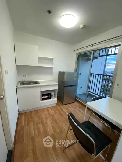 Modern compact kitchen with balcony view in urban apartment