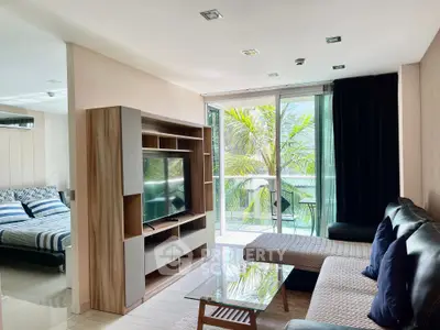 Modern living room with sleek furniture and large windows offering a lush garden view.