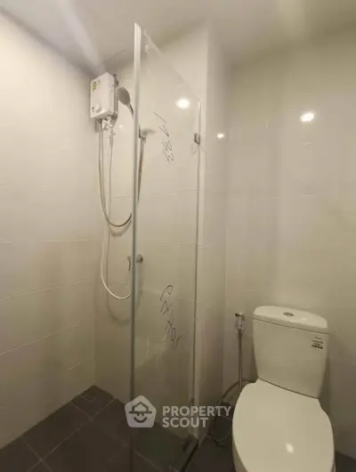 Modern bathroom with glass shower enclosure and sleek toilet design.