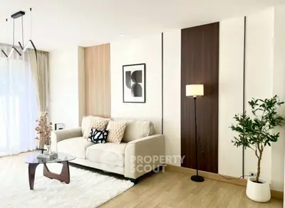 Modern living room with stylish decor, cozy sofa, and elegant lighting in a bright, airy space.