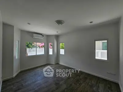 Spacious unfurnished room with large windows and modern flooring, perfect for customization.