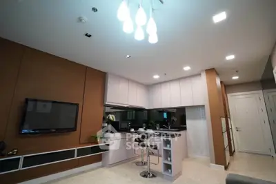 Modern open-layout kitchen with sleek design and stylish lighting in a contemporary apartment.