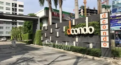 Modern condominium entrance with sleek design and lush greenery, showcasing urban living at its finest.