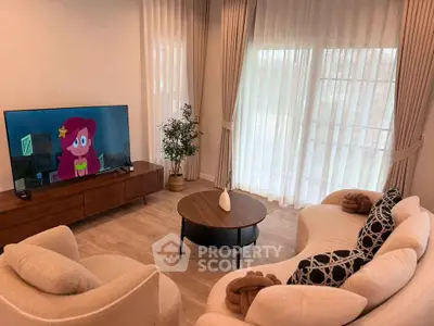 Elegant living room with modern furniture and large TV, perfect for relaxation.