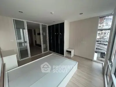 Spacious bedroom with modern design and large windows offering natural light.