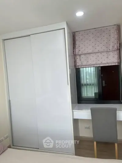 Modern bedroom with sleek wardrobe and cozy study nook