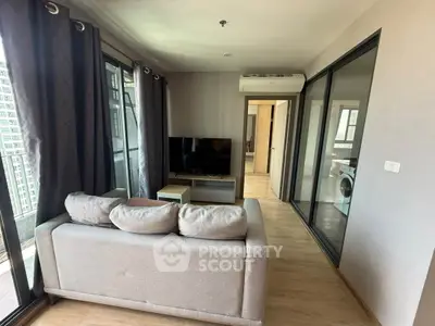 Modern living room with balcony view and washing machine in a sleek apartment.
