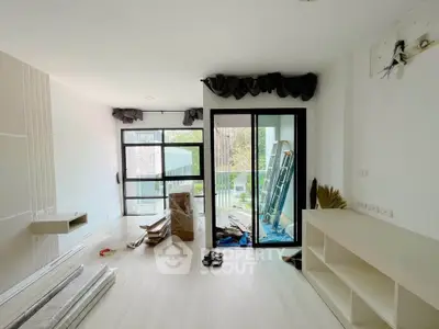 Spacious modern living room with large windows and balcony access, ideal for natural light lovers.