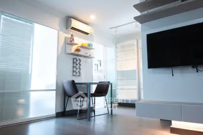 Modern living room with sleek furniture and wall-mounted TV in bright apartment