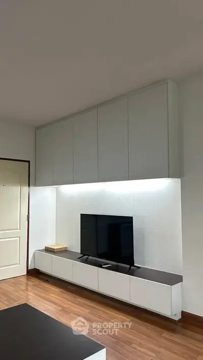 Modern living room with sleek TV unit and wooden flooring