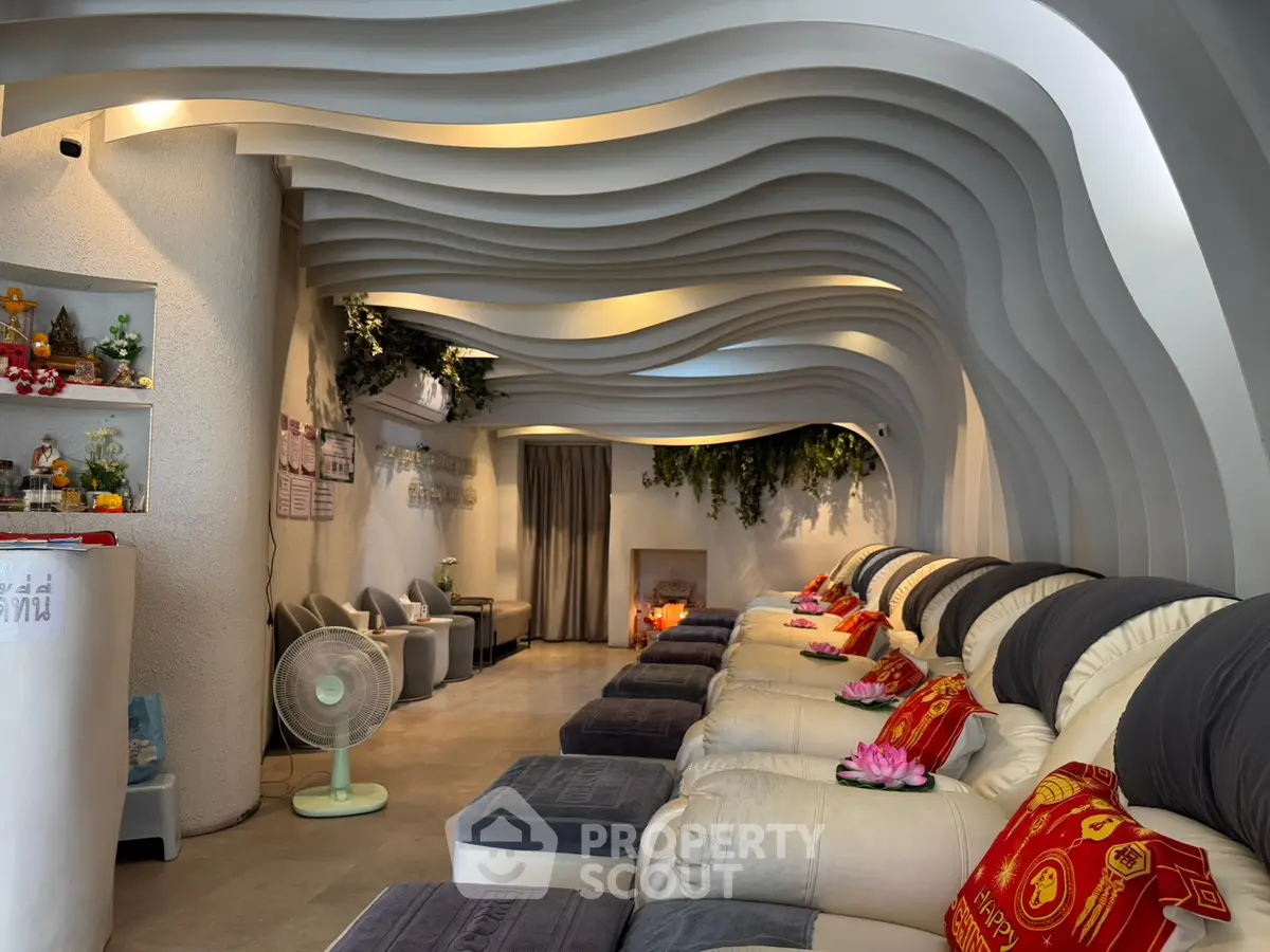 Luxurious spa-like living room with modern wave ceiling and plush seating for ultimate relaxation.