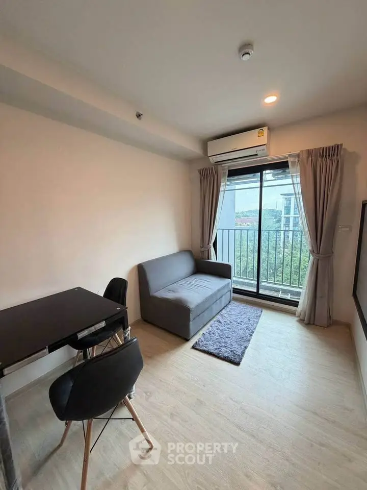 Modern living room with balcony view, featuring sleek furniture and natural light.