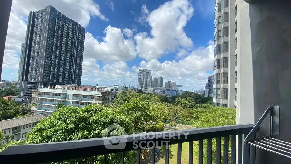 Stunning cityscape view from a modern balcony with lush greenery and high-rise buildings.