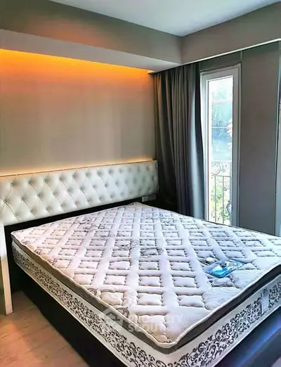 Modern bedroom with elegant lighting and large window for natural light.