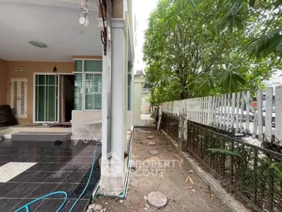 Charming outdoor patio with tiled flooring and lush greenery, perfect for relaxation and entertaining.
