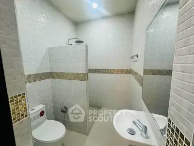 Modern bathroom with sleek design and tiled walls, featuring a shower and toilet.
