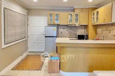 Modern kitchen with sleek cabinetry and stainless steel appliances in cozy apartment.