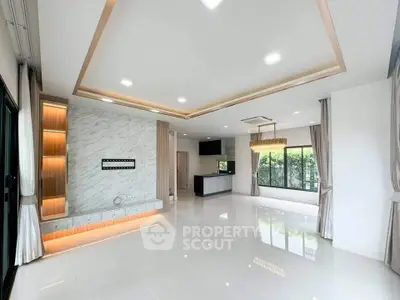 Spacious modern living room with elegant lighting and open kitchen layout, featuring large windows and marble accents.