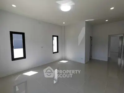 Spacious modern living room with large windows and glossy tiled floors