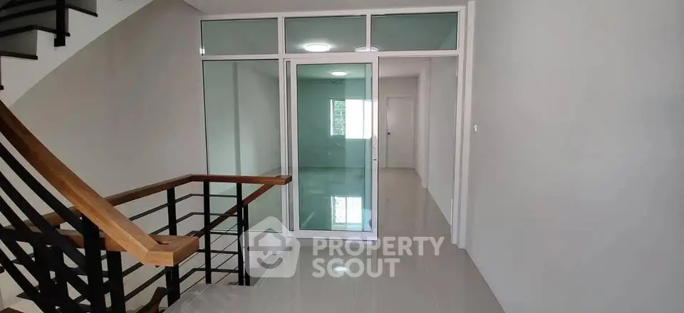 Modern townhouse interior with sleek staircase and glass partition
