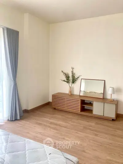 Minimalist bedroom with wooden flooring and natural light