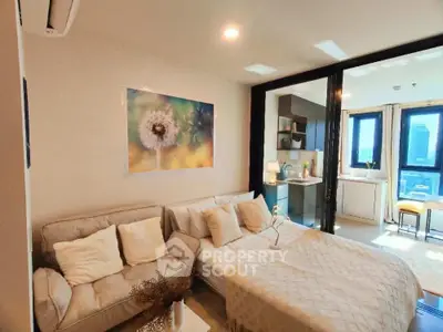 Modern studio apartment with cozy living area and open kitchen layout, featuring large windows and stylish decor.
